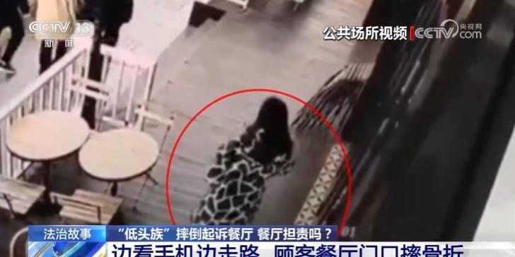 上海女子因低头玩手机不看路，在一家餐厅门口摔倒，导致腰椎骨折。女子反手将商场和餐