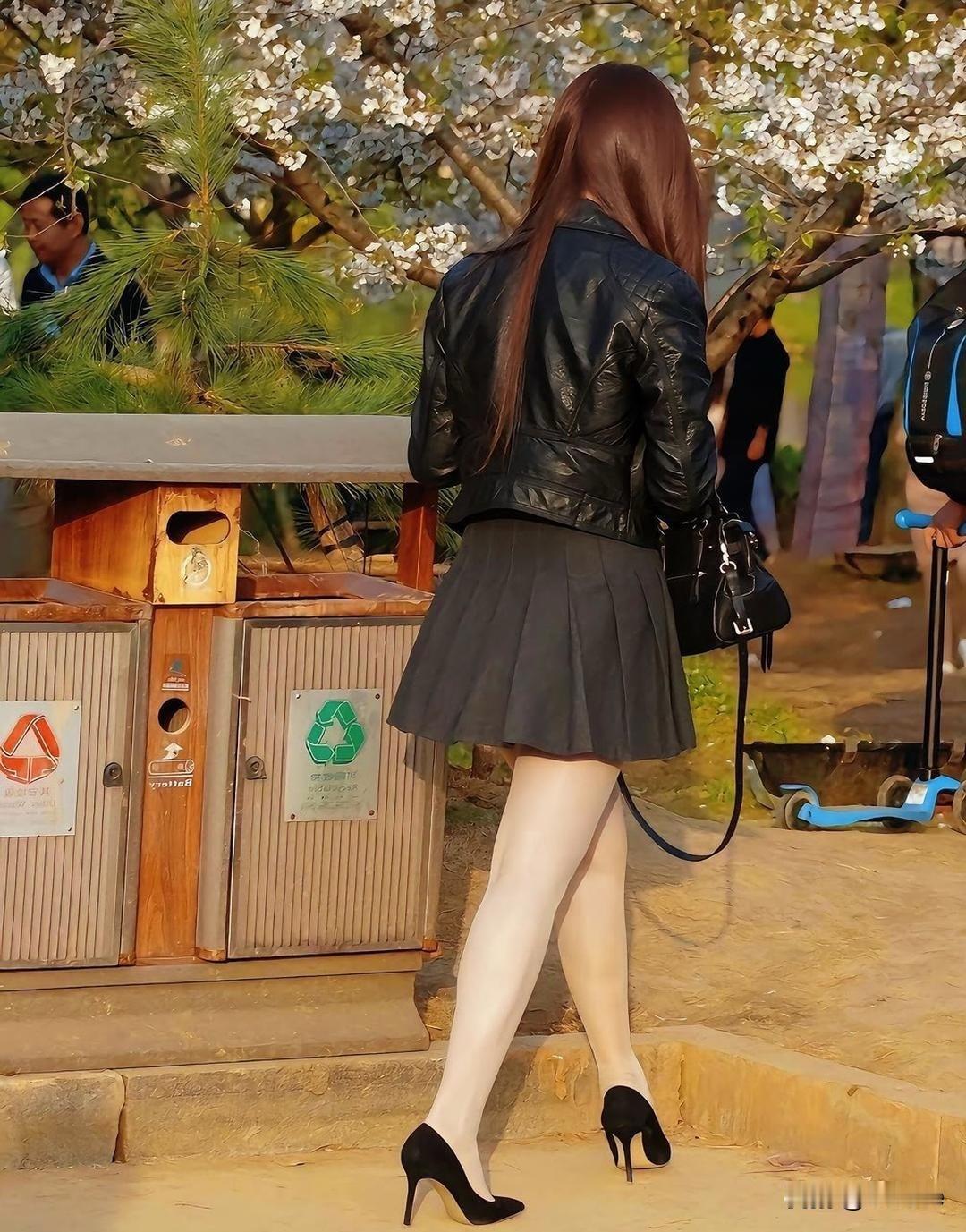 女孩在花树下，背对镜头。