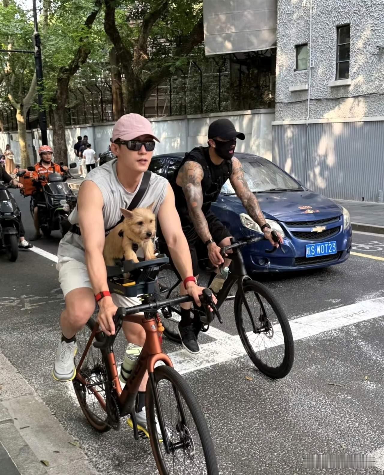 上海新天地又拍到黄景瑜，34岁还像个运动系男生。骑车出门遛狗，穿无袖上衣，整个人