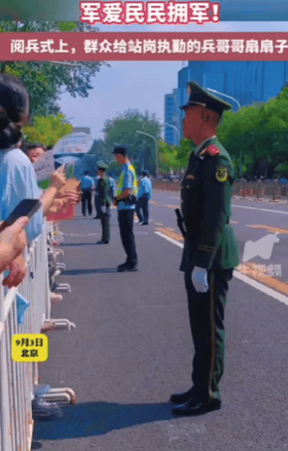 9月3日，北京，女子正在路边看阅兵，突然看见一位阿姨，拼命把手伸出护栏！