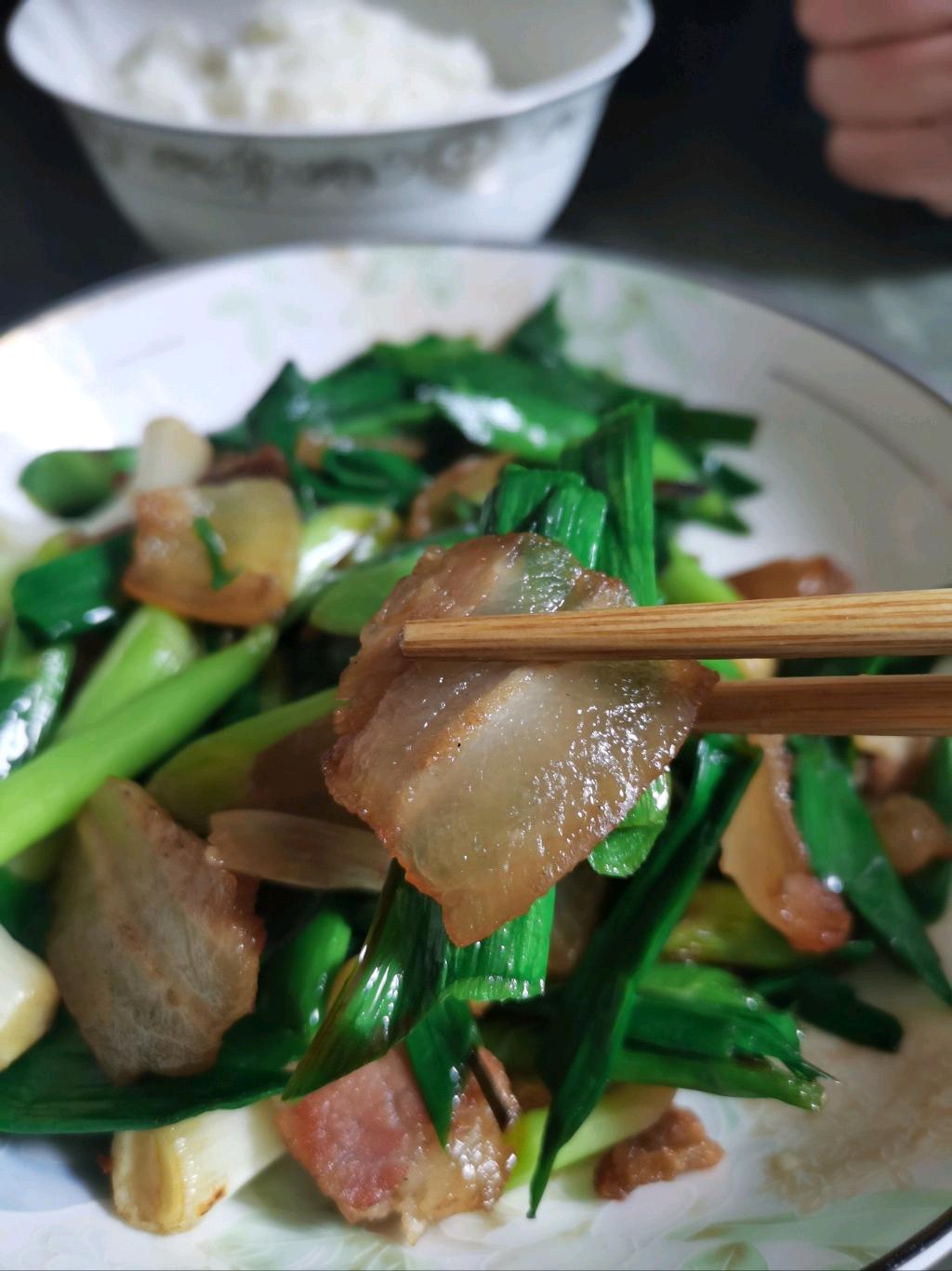 一男子下班回到家，见老婆端来的菜只有蒜苗炒腊肉，就说：“你都连吃两天的蒜苗炒腊肉