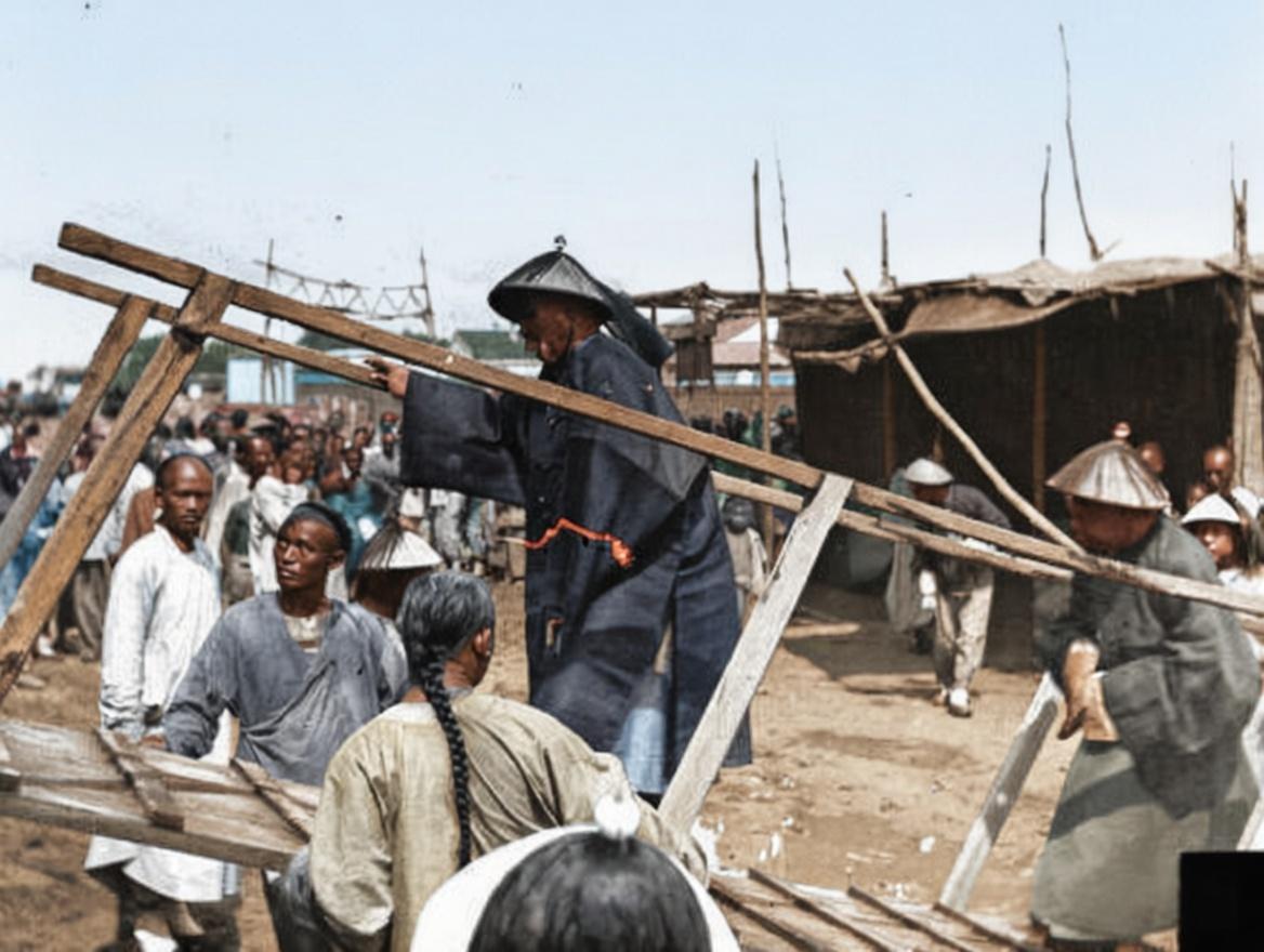 这张照片拍摄于清末的山东登州，一位地方官员在港口登船，官员身着清代官服，头戴顶戴