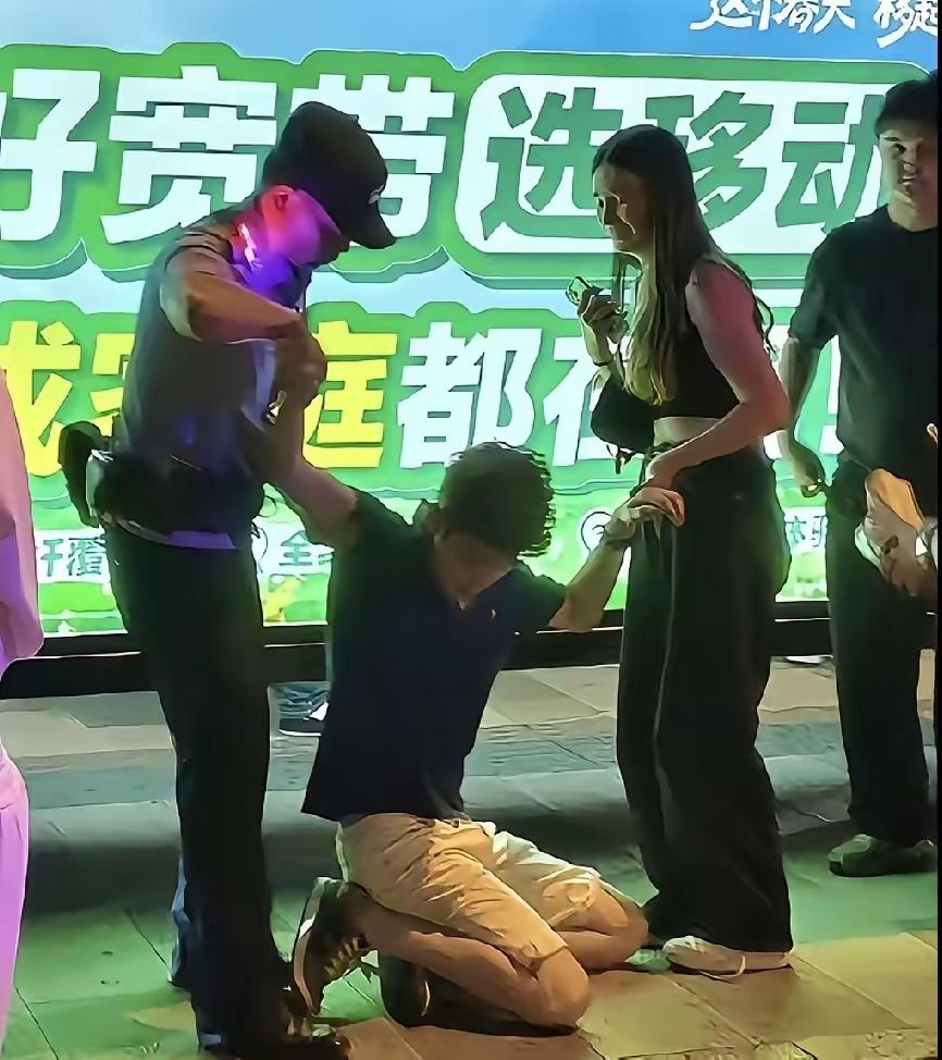 肇事的留学生被搀扶着才勉强站起来！看样子没少挨拳头！他女朋友也被吓哭了！希望他以