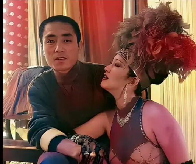 照片里，巩俐穿着戏服，整个人贴过去，眼神里全是“我认定你了”。张艺谋却像块木