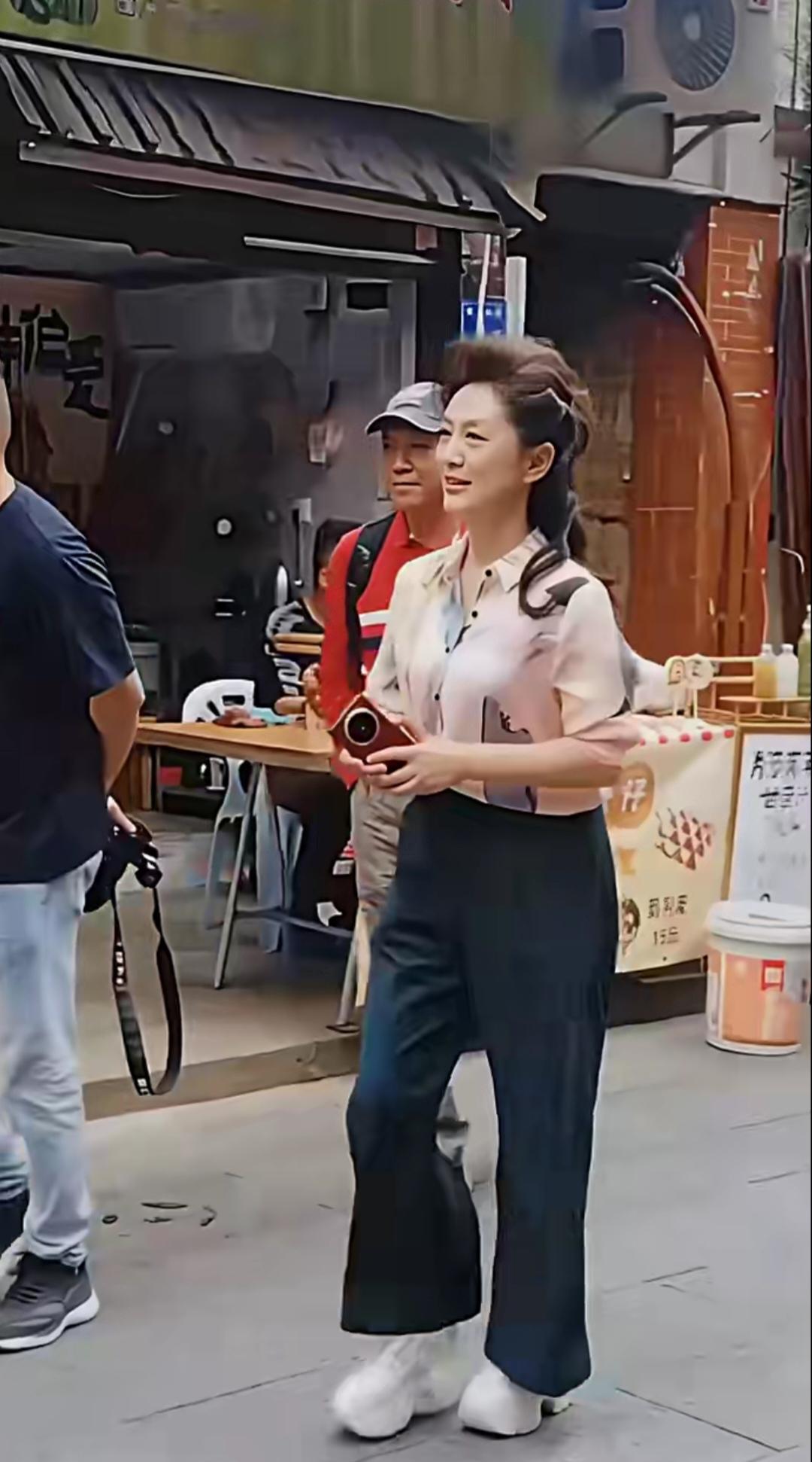 海霞现身福建漳州古城，浅粉印花短袖衬衫，色彩柔和淡雅，自带温婉气质盘发搭配侧编