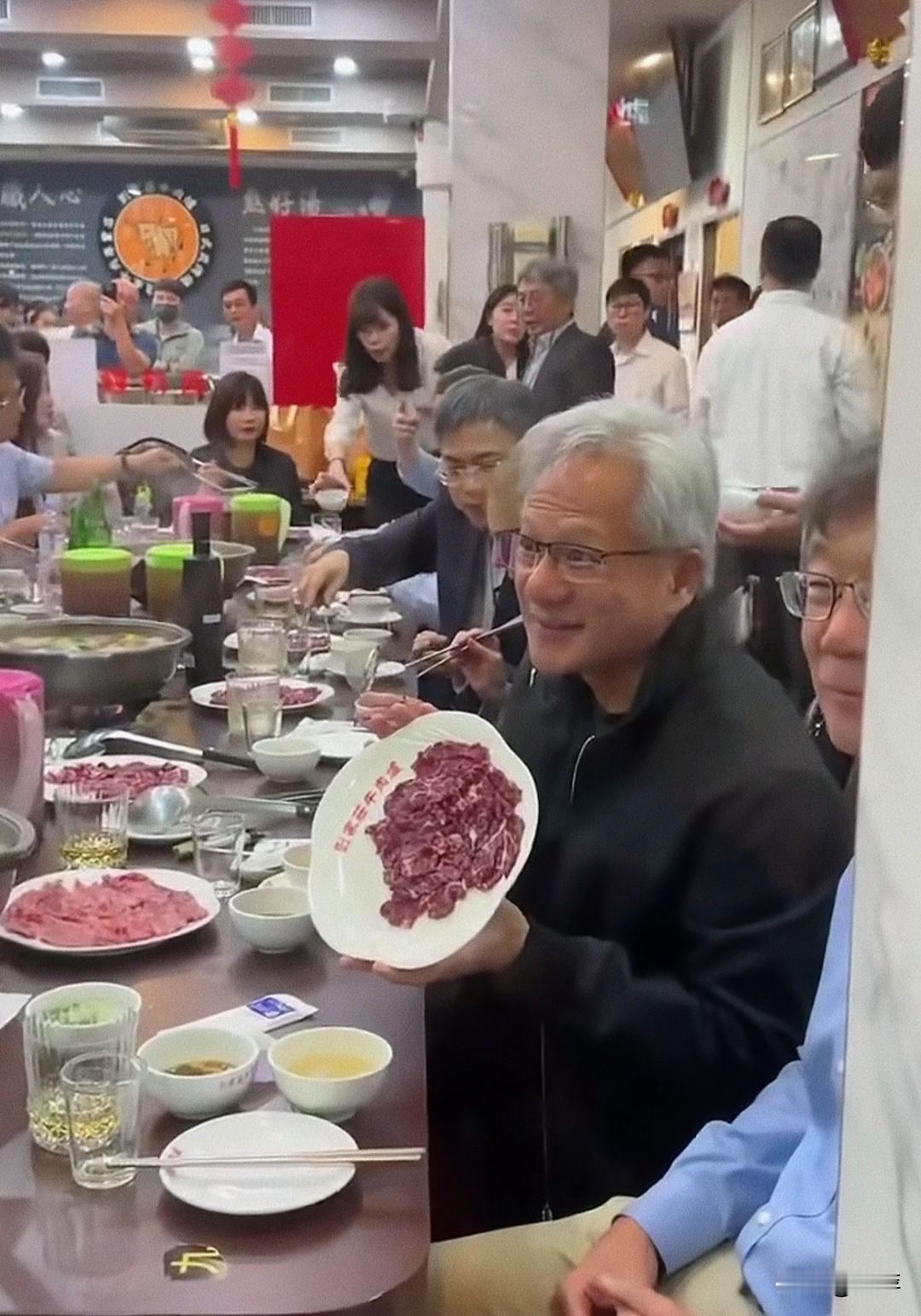 黄仁勋吃酸火锅展示盘子中的肉，没次看到他不是在吃东西就是在吃东西的路上。