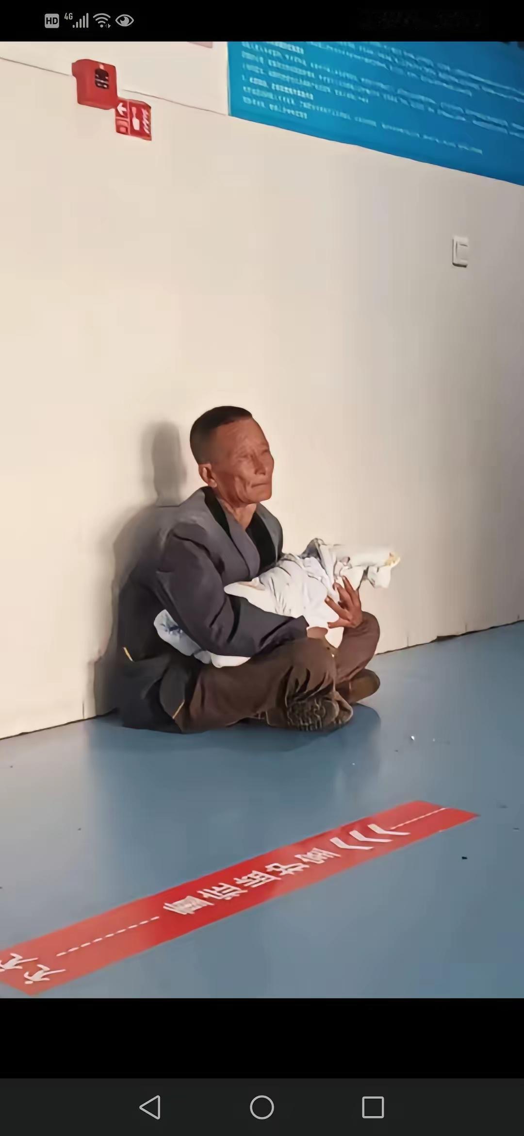 心酸，看哭了，老人抱着刚一岁的宝宝在医院地上坐着等挂号，给宝宝看病，别人问他，是