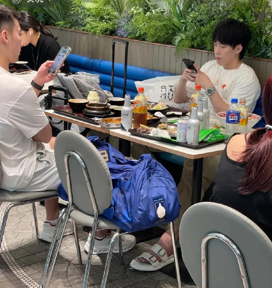 刷到在仁川机场转机的王楚钦啦，在美食广场和大家一样，桌边摆着吃喝，低头看手机，超