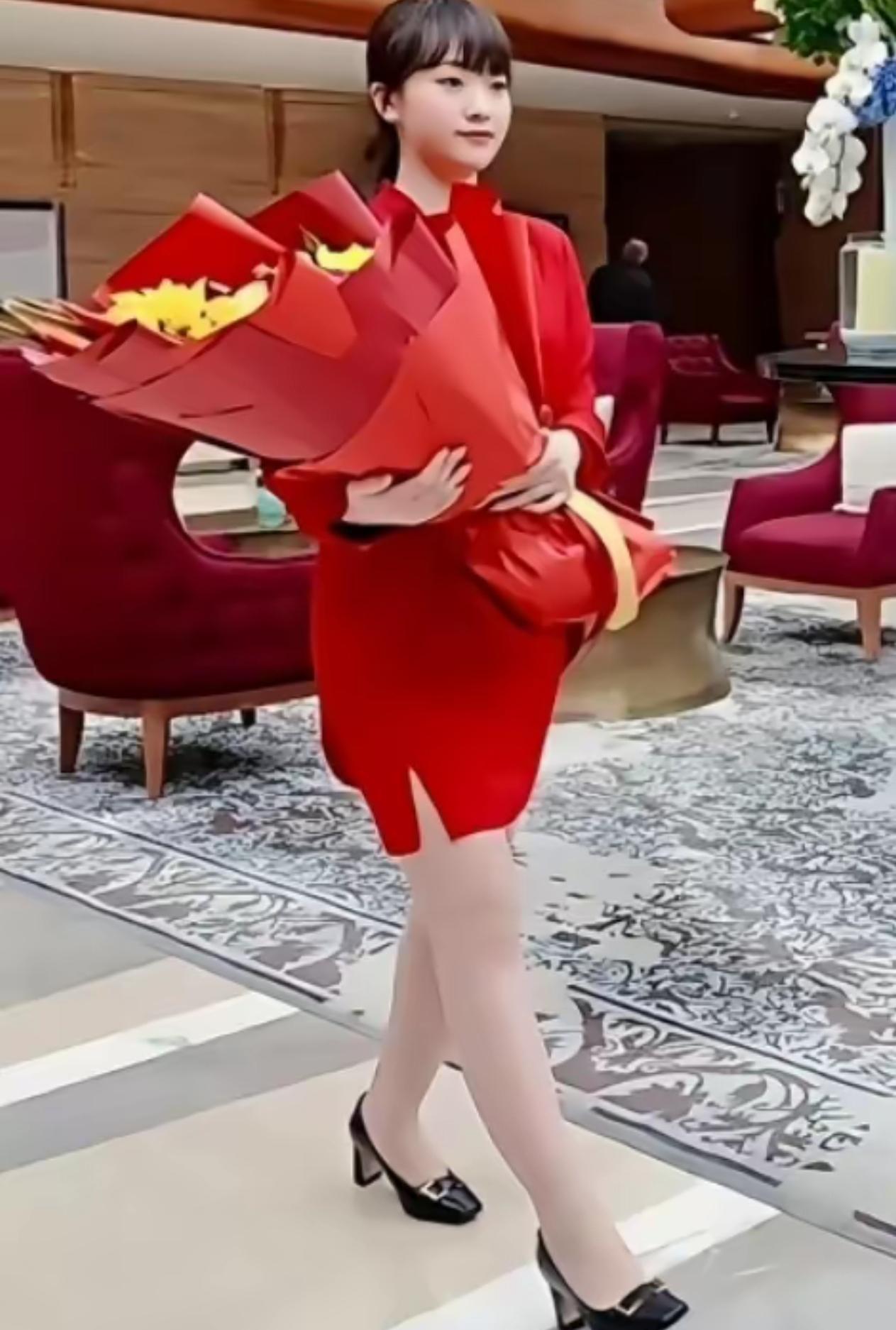 这就是那位外事接机献花的红裙小姑娘！一身红裙，不卑不亢。举手投足间，全是我们
