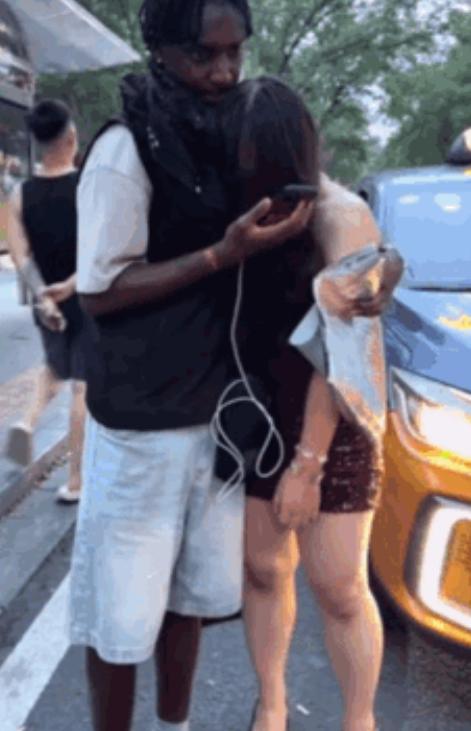 一黑人男子搂着年轻女子，女子站在原地一动不动，脑袋埋在男子怀里。一开始大家都以为