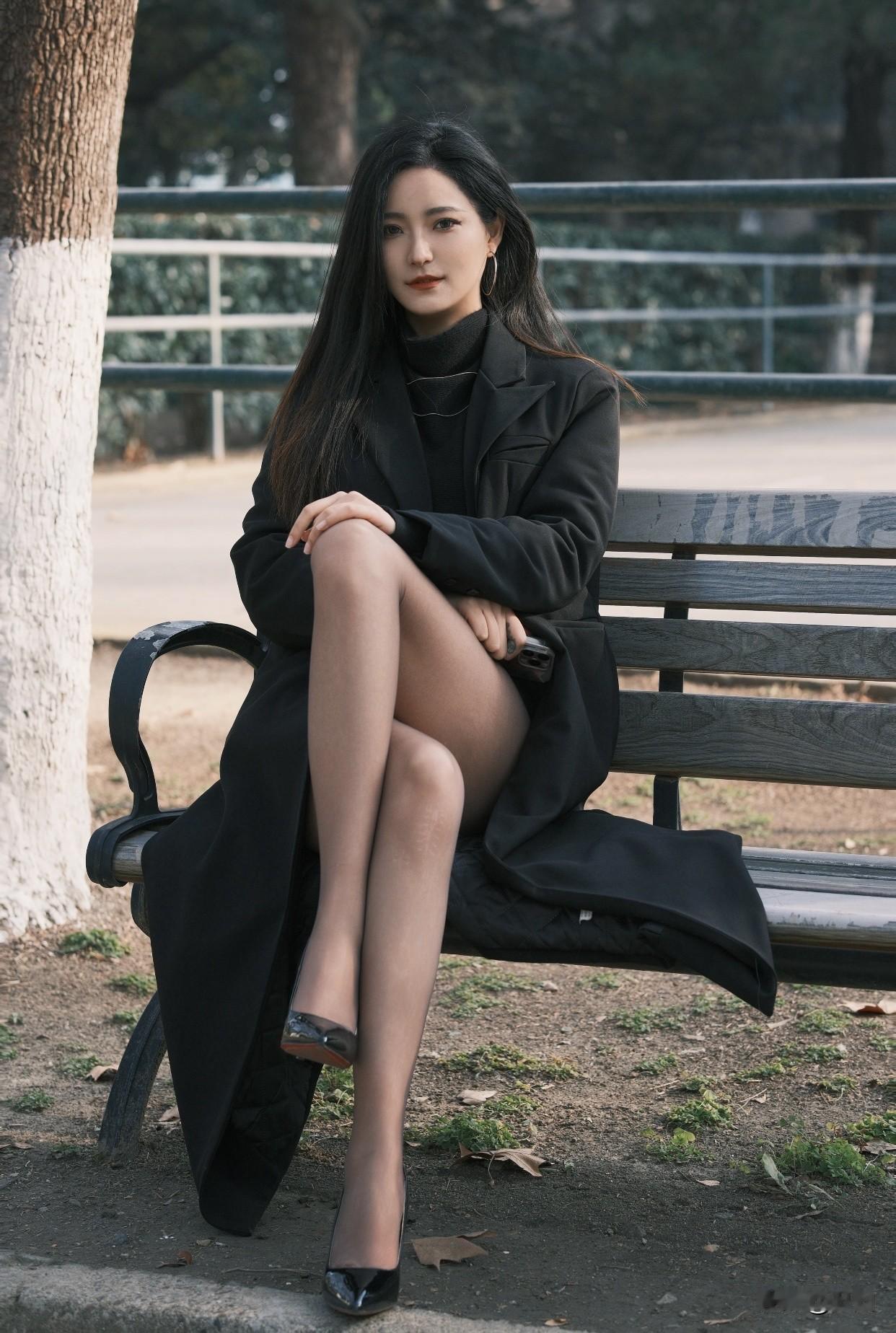 治愈系少女写真怎么拍秋日午后，黑衣女子静坐长椅，沉思手机，岁月静好。