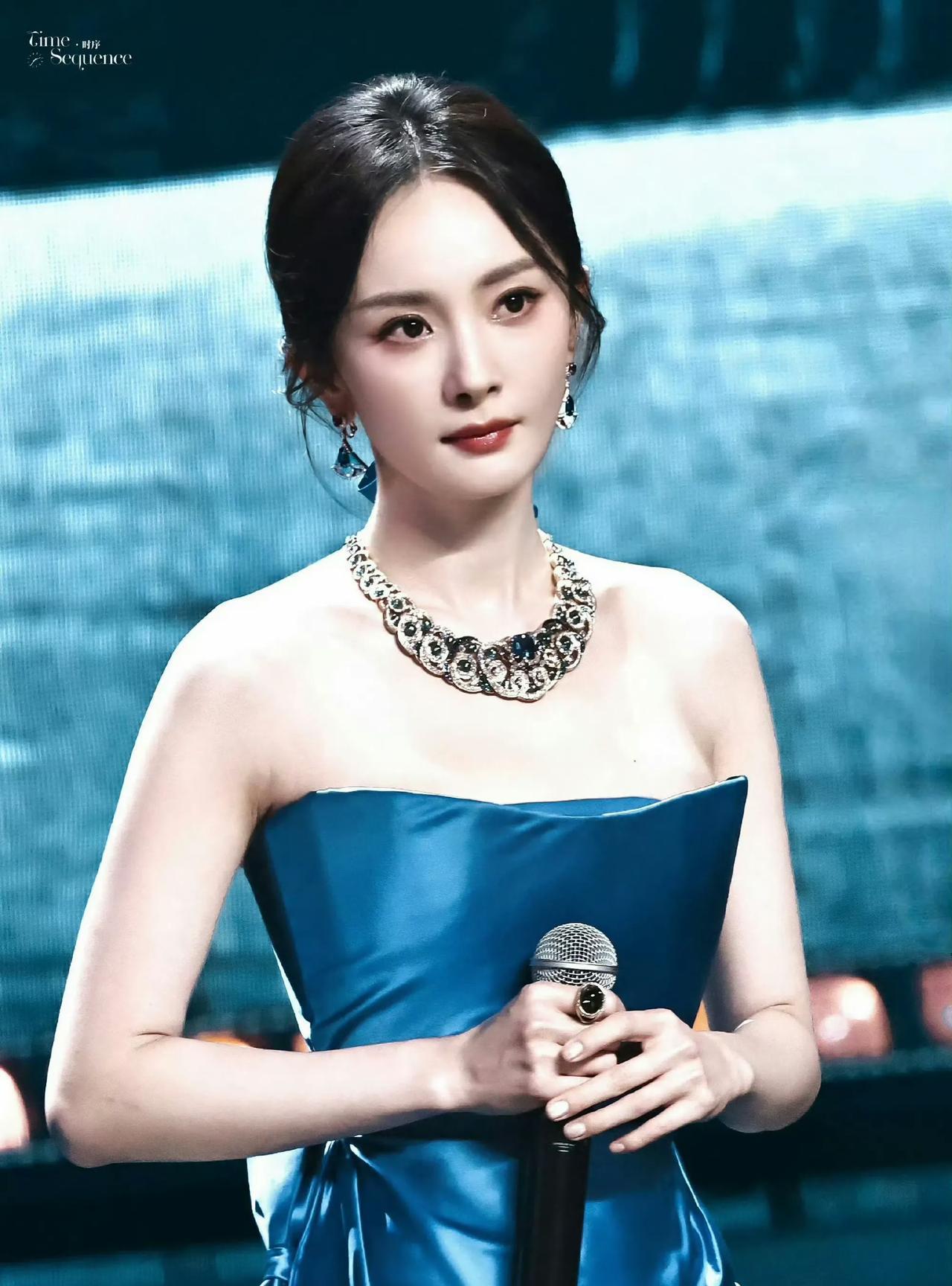 #杨幂#宝蓝缎面晕染流光，珠宝在颈间织就星芒。舞台中央，她以从容姿态执掌话筒，发