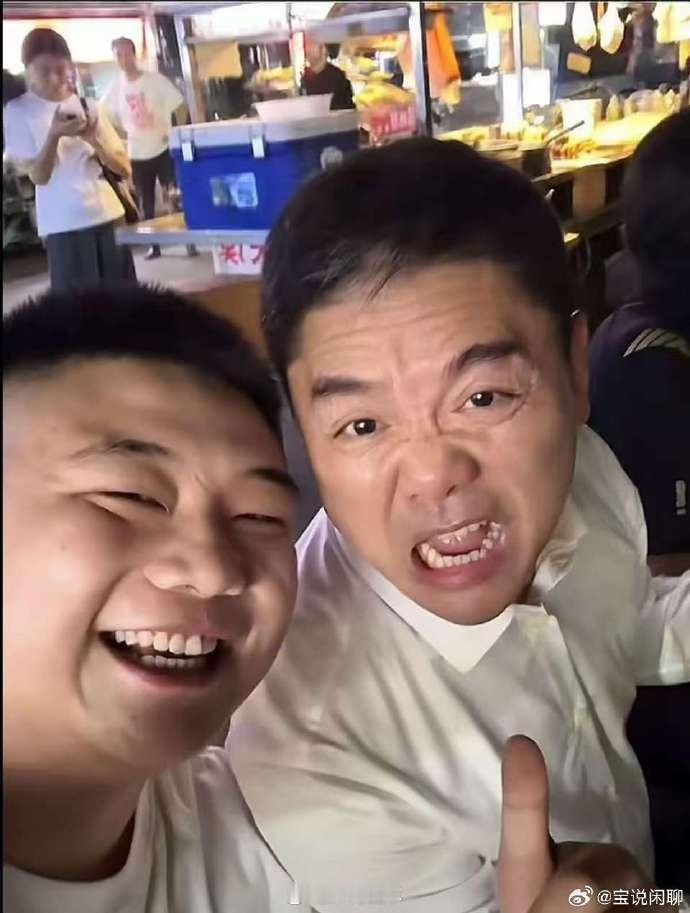 刘强东夜市用塑料碗和乡亲们喝酒刘强东穿白衬衫，坐塑料凳、用一次性碗跟乡亲喝酒，