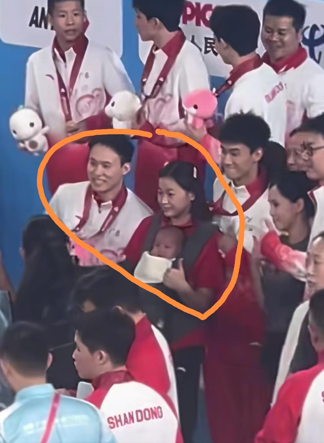 11月3日，全红婵抱着师兄谢思埸的宝宝站在领奖台上与大家合影，开心的不得了，这半