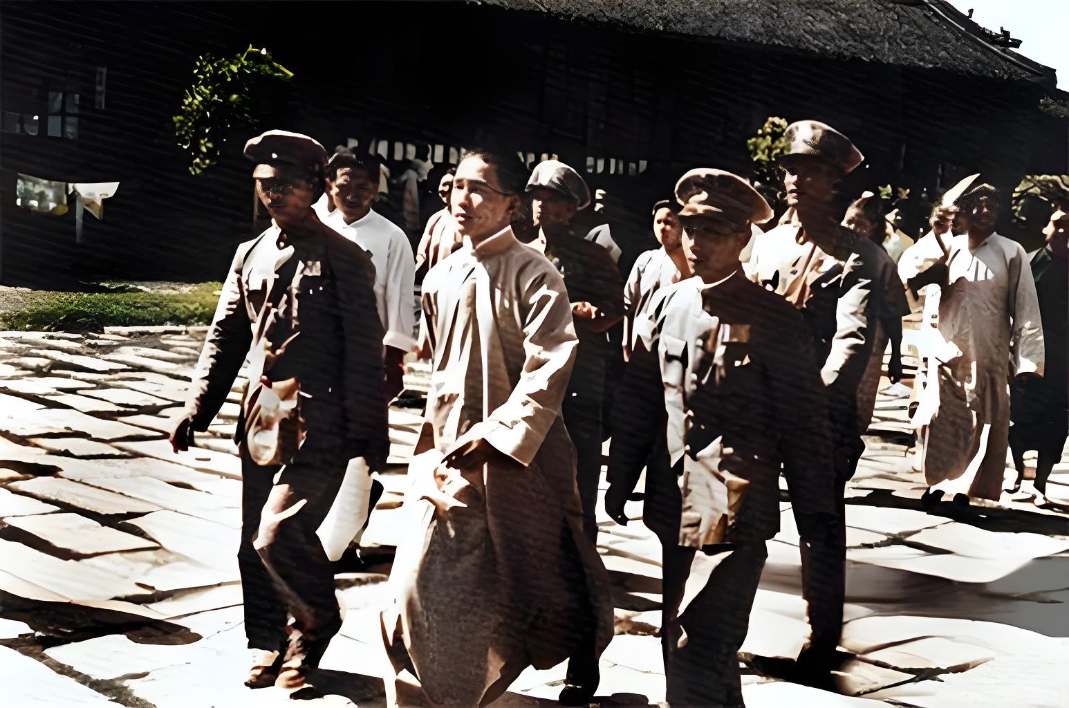 1946年，在南京，画面里，身着长袍的汪文悌面容青涩，在几位身着军装的人员陪同（