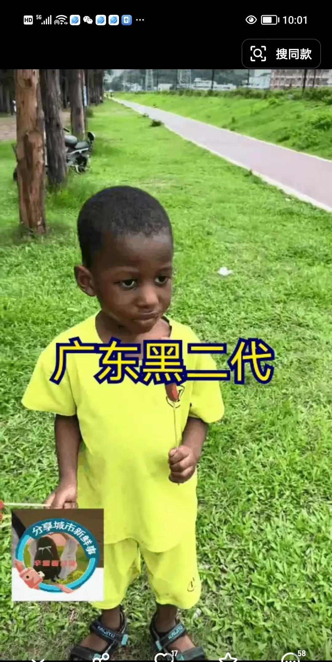 黑人在中国真幸福，这是广东某地景区一名黑人儿童在游玩的时候，开心的吃着烤肠。你