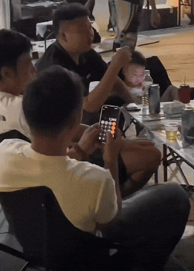 别人在喝酒聊天，唯独一名男子捧着手机，手指在计算器上胡乱按一堆数字，时不时还对着