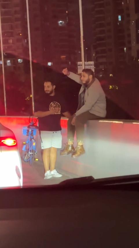 11月11日，上海，2名外国人骑共享单车上高架，一人淡定的坐在高架上，另一人则在