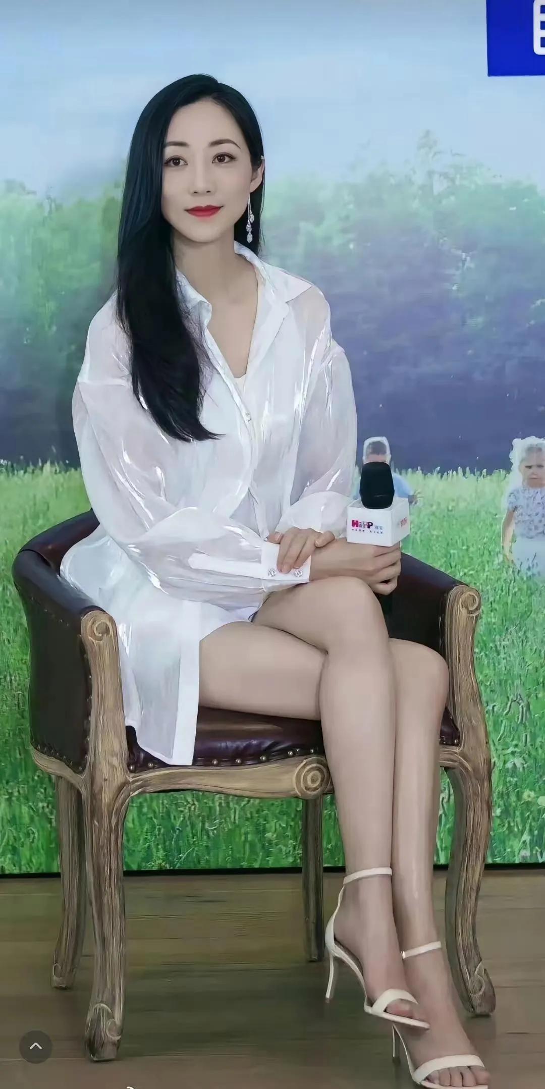 韩雪这一身活动造型，简约又很有女人味。光泽感白色长款衬衫裙，长发柔顺披肩，搭配
