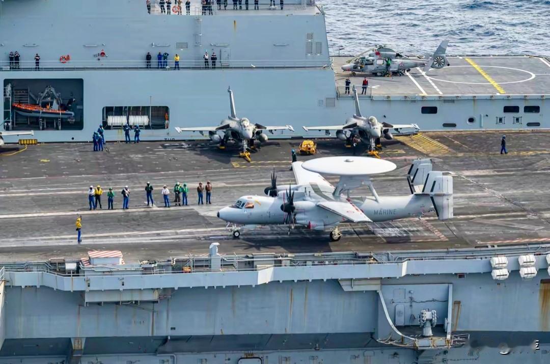 法国“戴高乐”号航母的甲板运作场景，清晰展现了其主力舰载机阵容。近处是一架E-