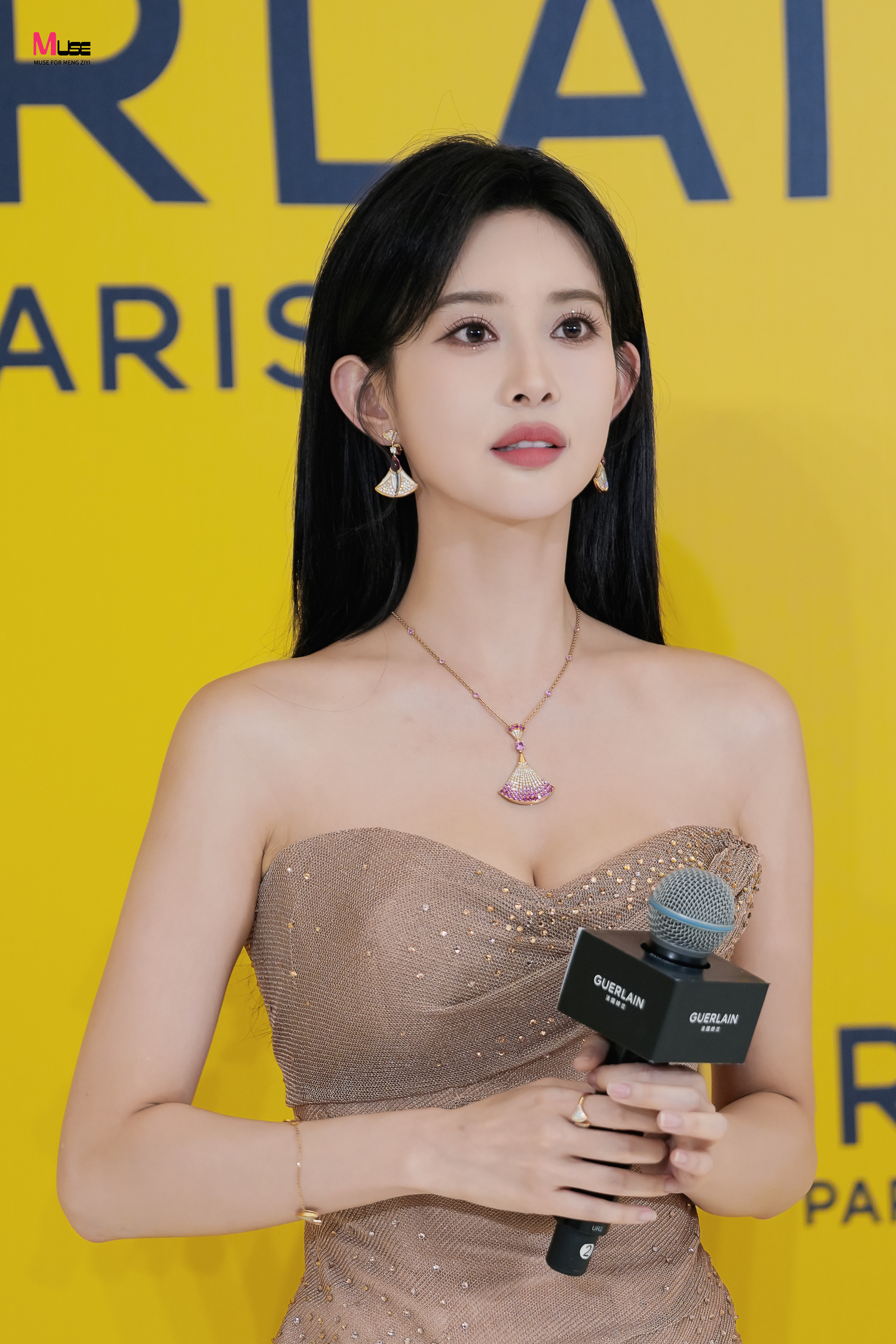 孟子义一袭裸粉色抹胸礼裙，裙身细碎亮片如繁星洒落，勾勒出曼妙身姿。乌黑长发垂落
