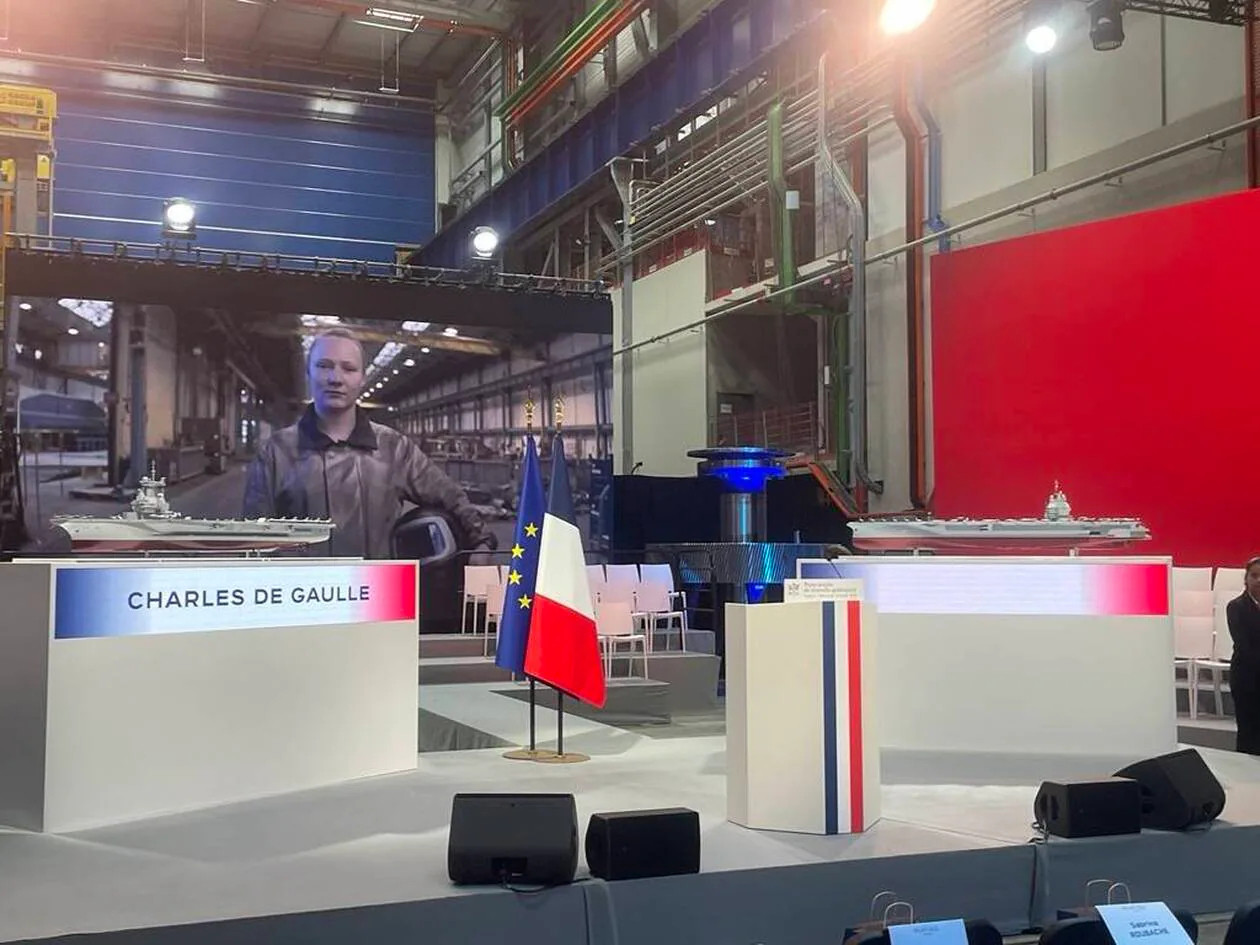 马克龙将在几分钟后向官员们发表讲话。即将发表讲话的平台上摆放着两个模型。其中一个