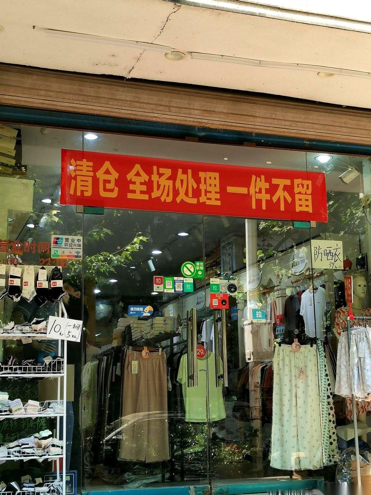 刚拐进商业街，我就被一家店门口的阵仗镇住了。红色的打折牌子，从玻璃门一直贴到天