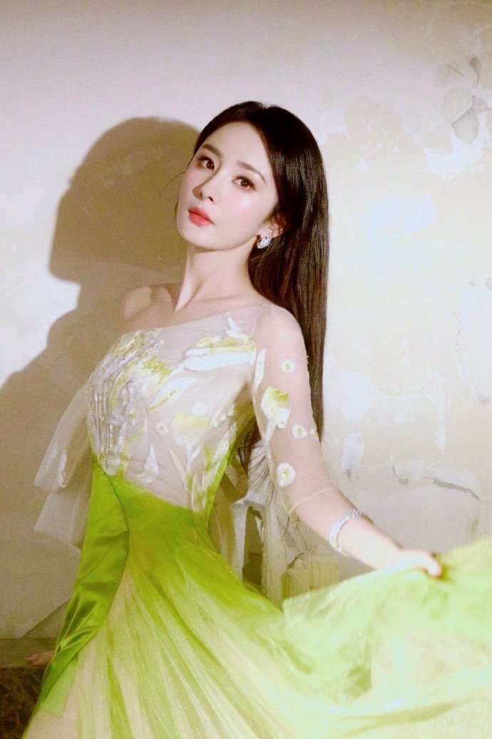 杨幂身着一袭翠绿色轻纱长裙，轻盈步入众人的视线。裙摆随风荡漾，如碧波般柔美飘逸。