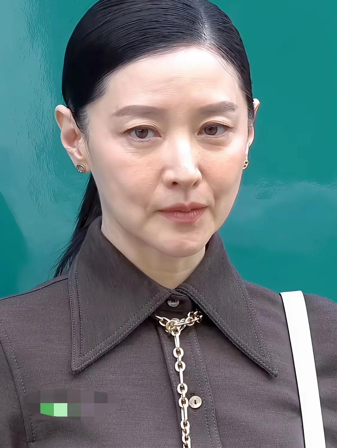 今年已经五十四岁的李英爱,今天穿得真有气质，灰色衬衫搭配金色项链，简约中透露着