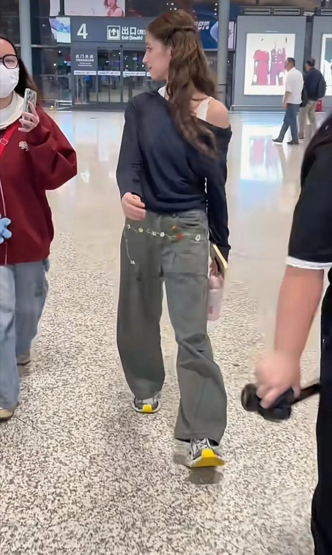 21岁欧阳娣娣机场亮相，微卷发慵懒随性，打底衫配阔腿裤简约利落，时髦中透着高级感