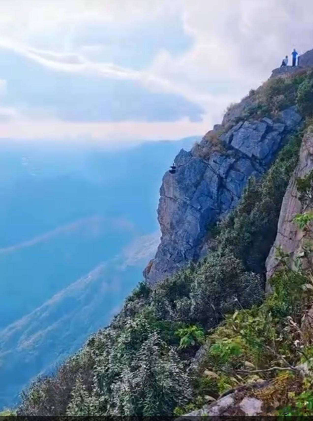 世界之大无奇不有广东东莞银瓶山森林公园内一男子在无防护栏的悬崖边好像在修行