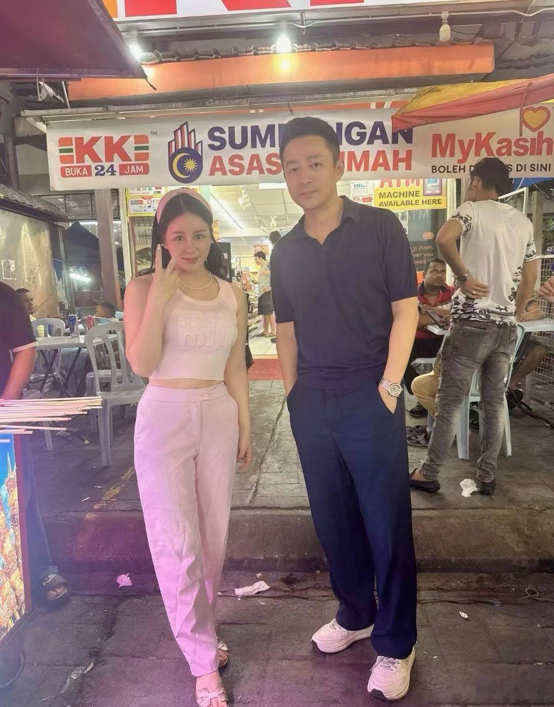 汪小菲在马来西亚一家路边摊吃烤羊肉串，并且和美女老板娘拍摄了合照。他的状态挺好的