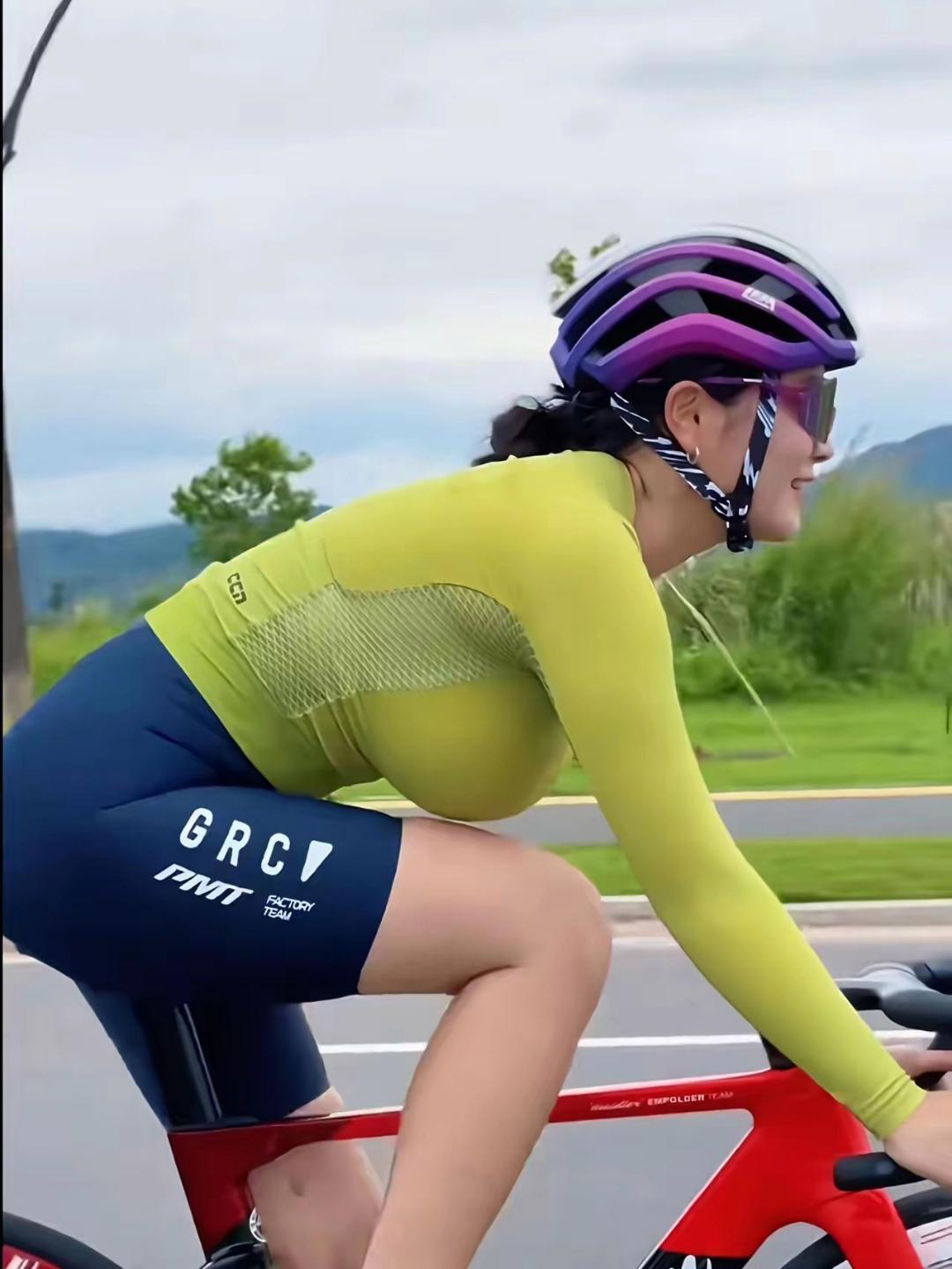 姐姐骑行时的风采太迷人！亮黄上衣贴合身姿，尽显健康活力，深蓝短裤勾勒优美腿部线条