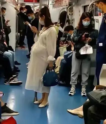 上海地铁9号线，一个平常的下班高峰，车厢里挤满了人，空气闷闷的，一位看着怀孕六七