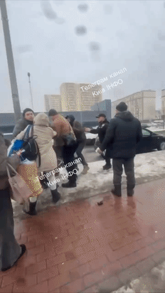 勇敢的大妈，乌克兰基辅街头，天寒地冻的征兵办还出来办事，抓到一个小伙子，几个年轻