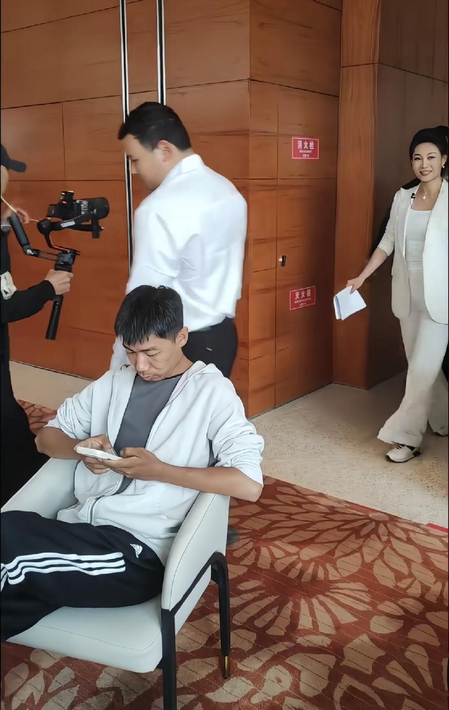 李梓萌参加线下活动，和主持新闻时完全不一样，她穿了白色的西服，大腿比较粗，还穿了