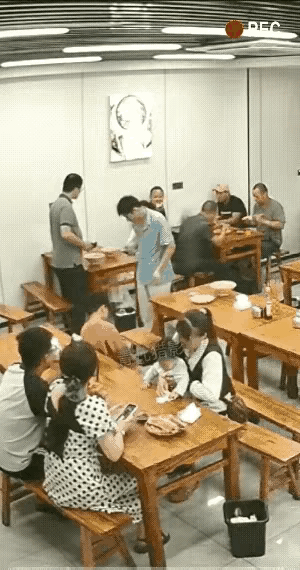 一对情侣在餐馆吃饭，不知何故女子将面前的一碗面一巴掌推了出去，眼瞅着饭汤四溅，女