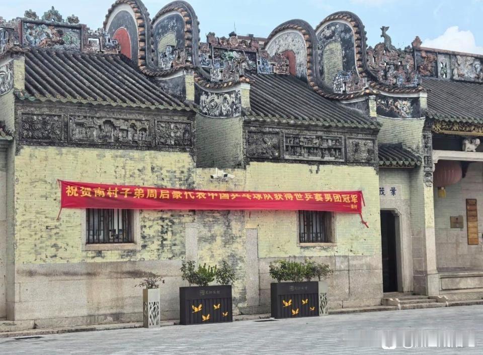 祝贺周启豪，周启豪的家乡拉出横幅，祝贺他代表中国乒乓球队获得世乒赛男团冠军！