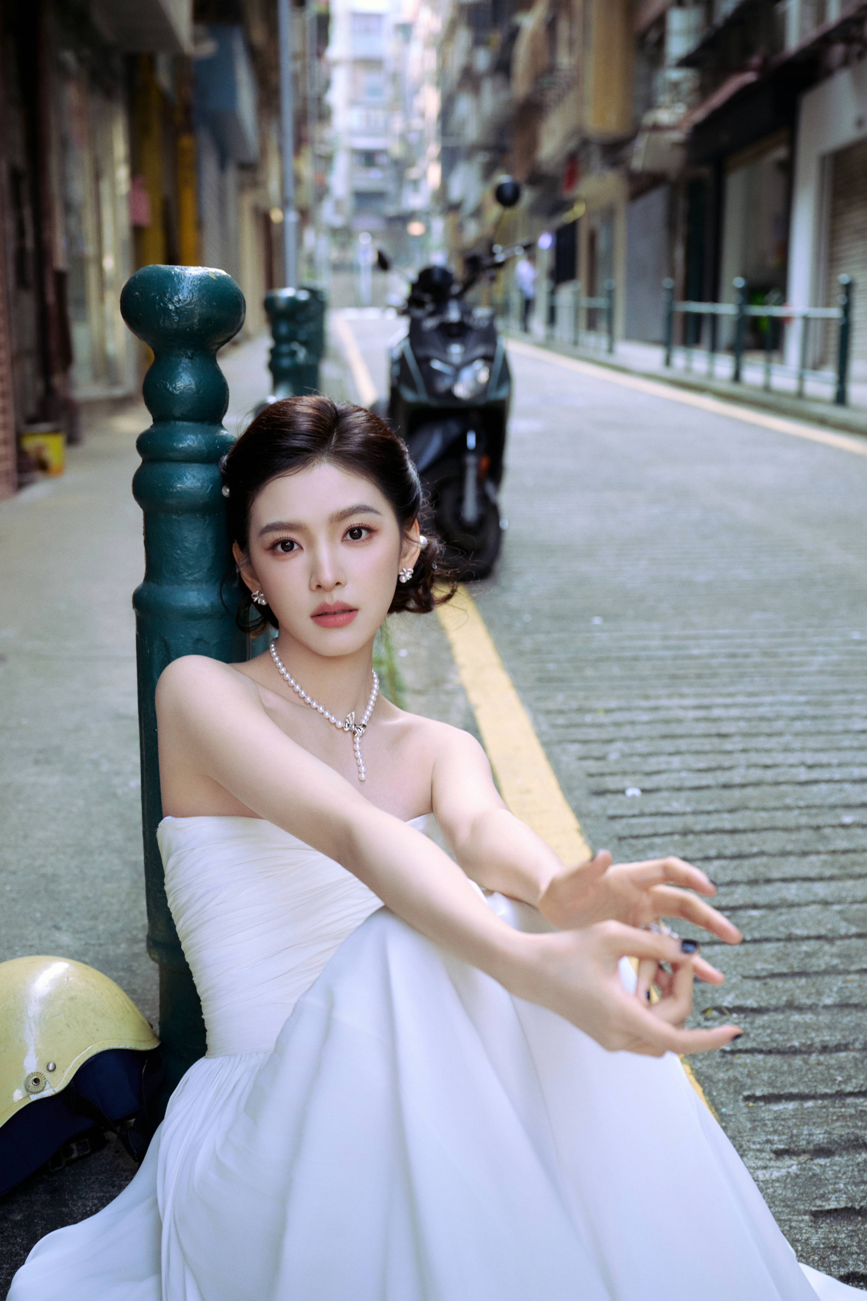 章若楠一袭极简白裙勾勒出流畅的肩颈线条，无袖抹胸设计利落又高级，垂坠的裙摆自