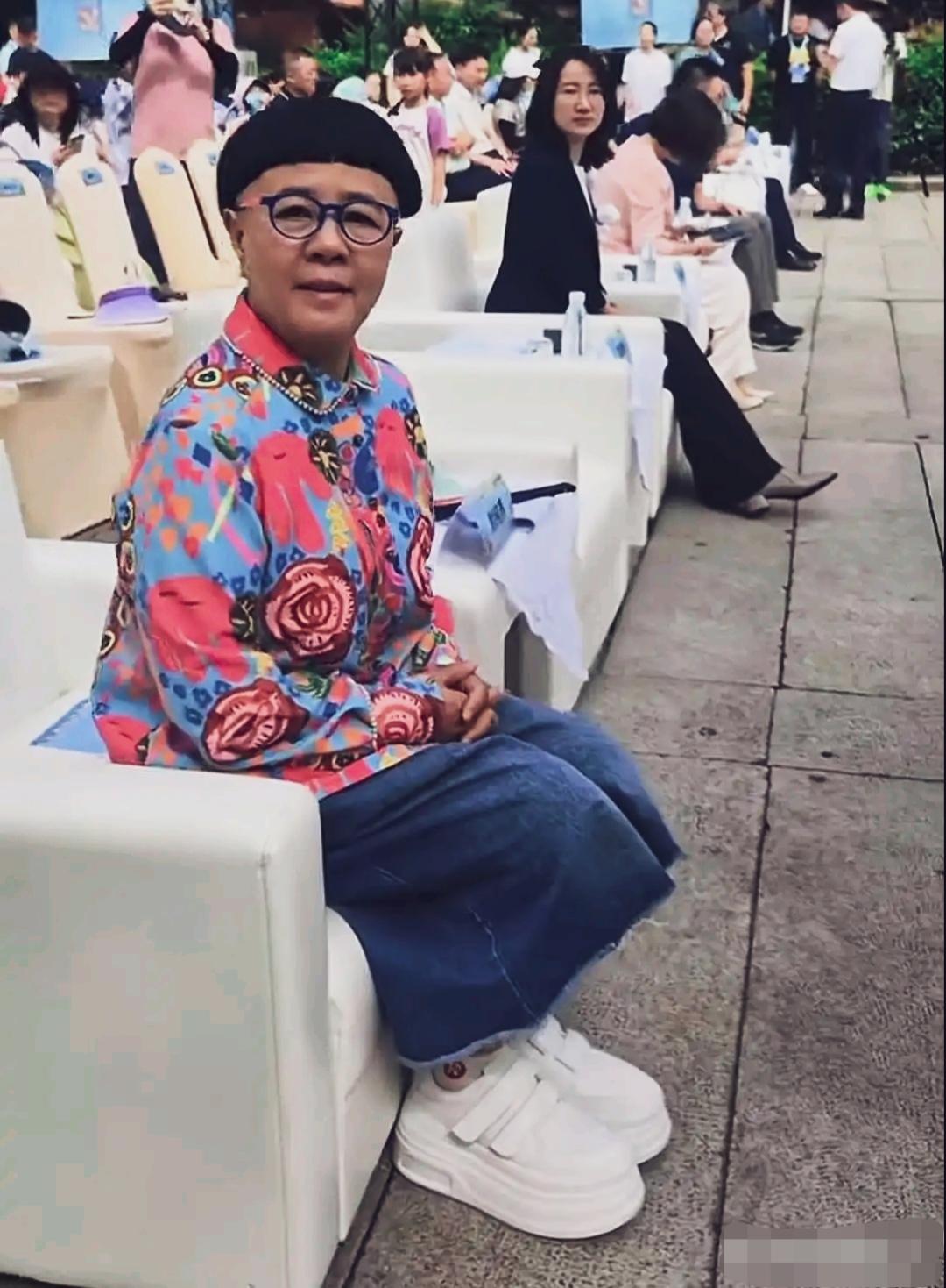 刘纯燕出席活动，路人镜头下的她留着经典锅盖头，搭配撞色圆框眼镜。她身鲜艳的花上衣