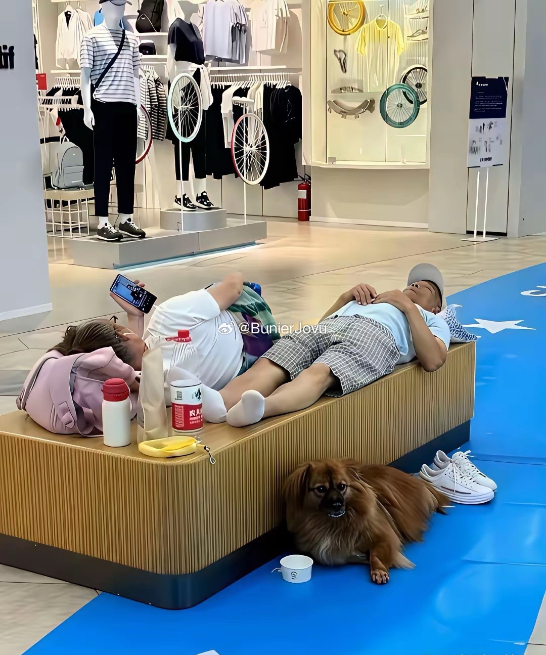一家三口商场蹭空调，小狗趴地上睡，休息台被夫妻直接当成自家大床，这下能省下不少电