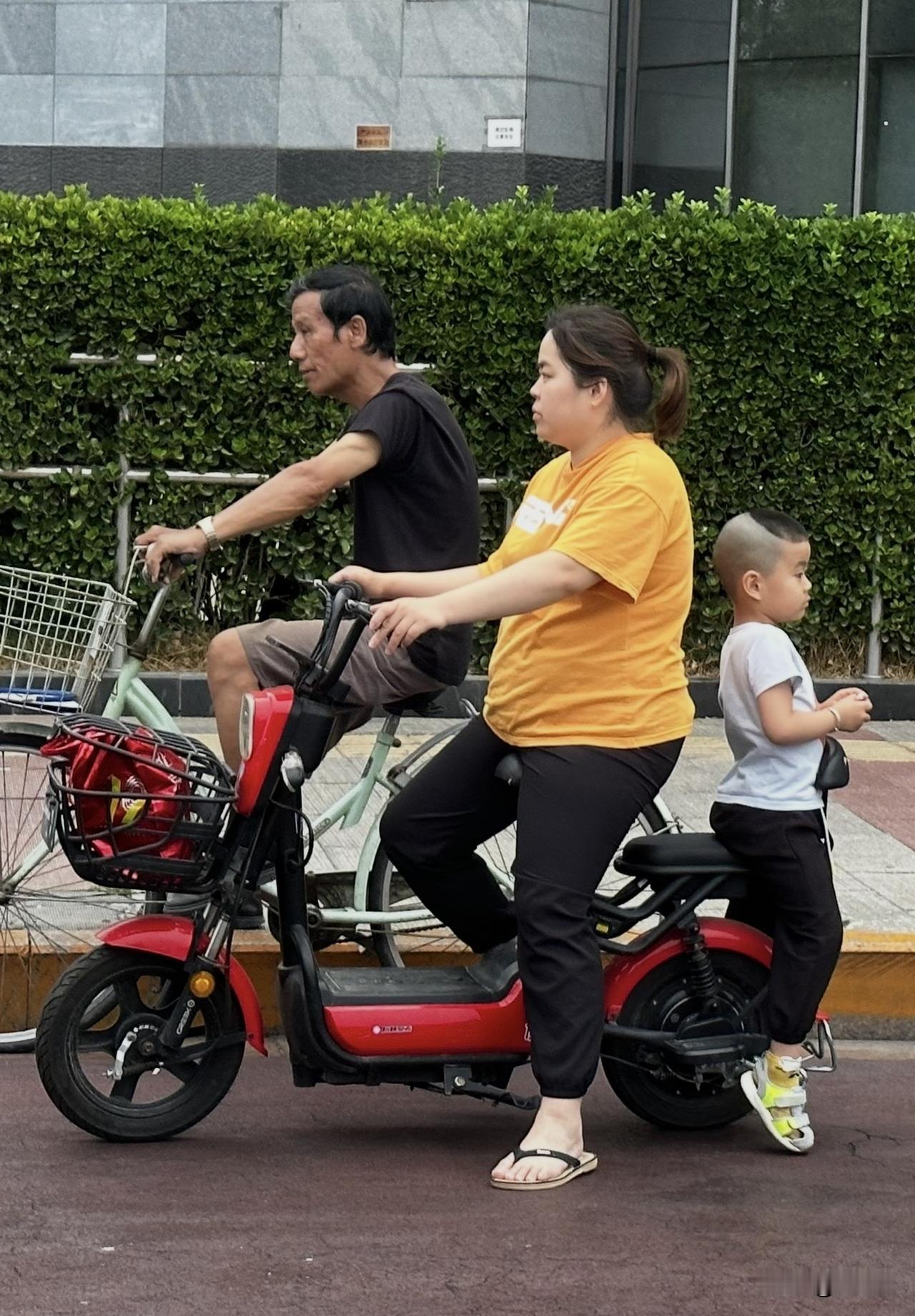 骑车这么带孩子太危险了吧？我打开车窗怎么喊她都不理我。我看到前面有交警，就开到前