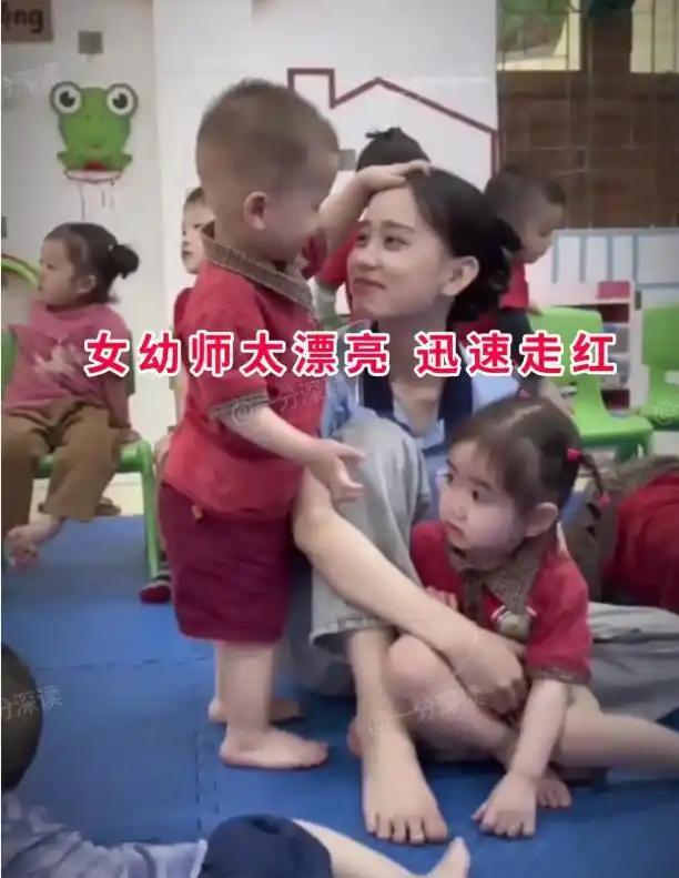 幼儿园里温暖的一幕被拍了下来，这位年轻幼师因为长相清秀温柔，迅速走红网络。