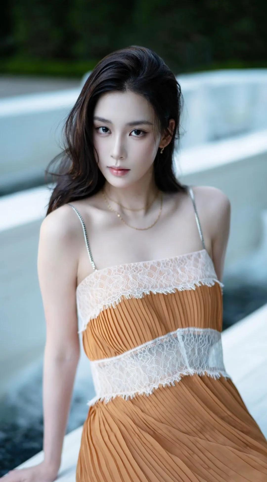 夏日午后，我穿着那条心爱的橘色蕾丝吊带裙，漫步在绿意盈盈的小公园。阳光透过树叶的
