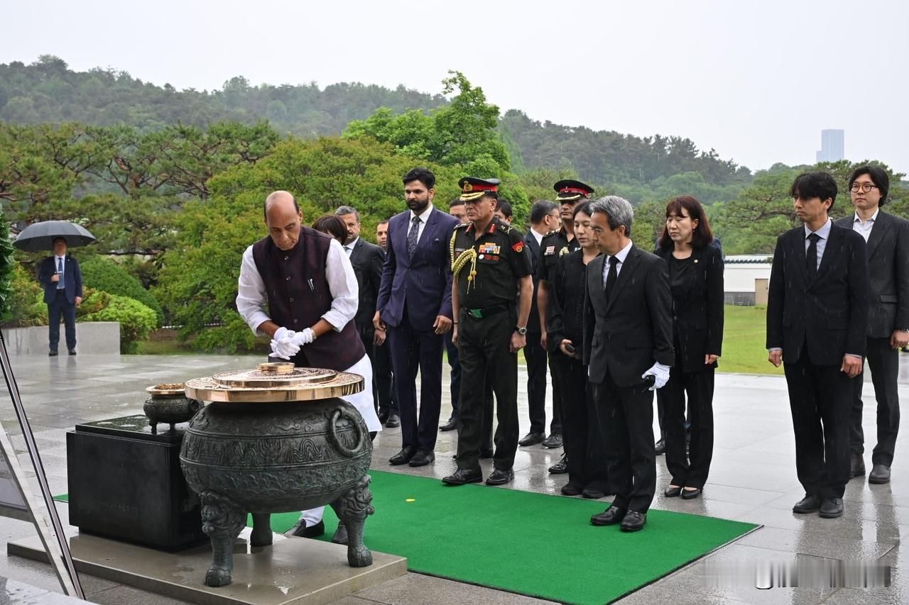 客人不打伞，礼兵穿雨衣。印度国防部长辛格访问韩国，参拜国立公墓显忠院。期间天降大