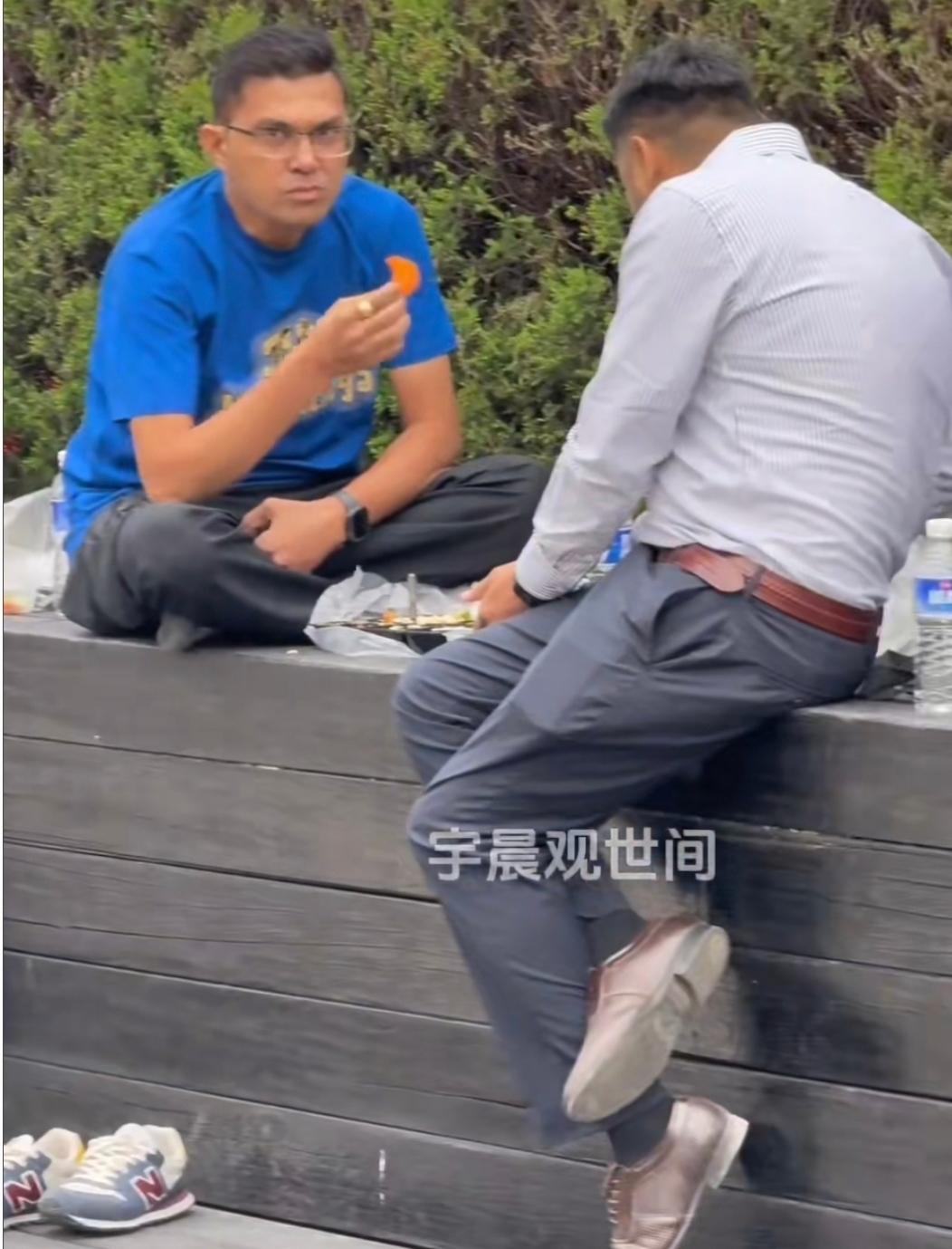 印度游客打卡上海外滩，逛饿了直接在观景台的花坛边上脱鞋、盘腿，铺开自带的食物用手