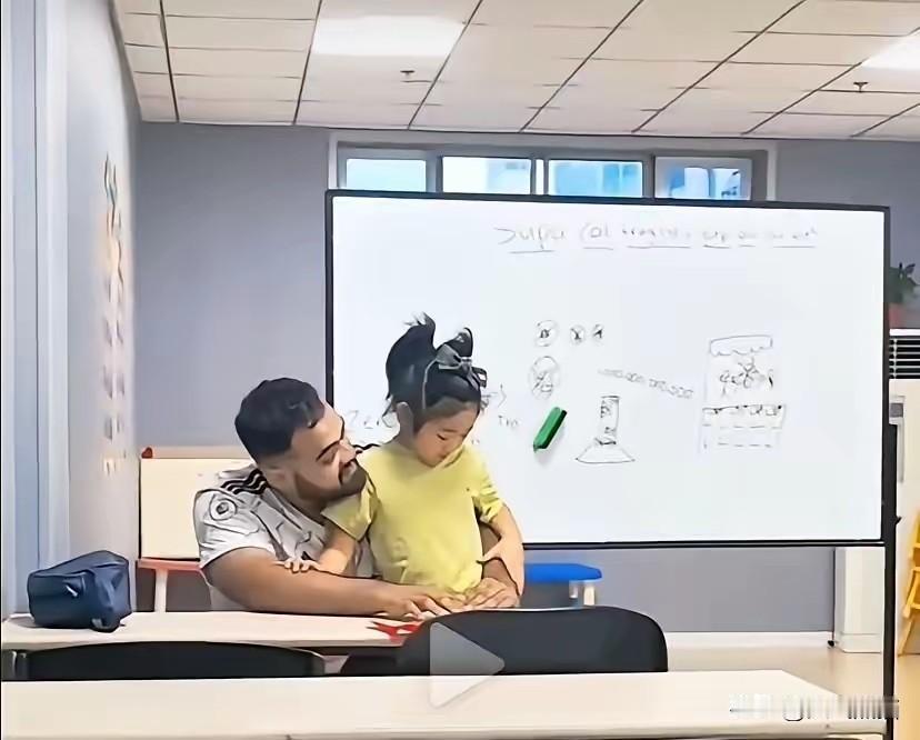 这是孩子母亲自己上传的外教上课视频，一个男外教直接把年纪很小的小姑娘整个人抱在怀