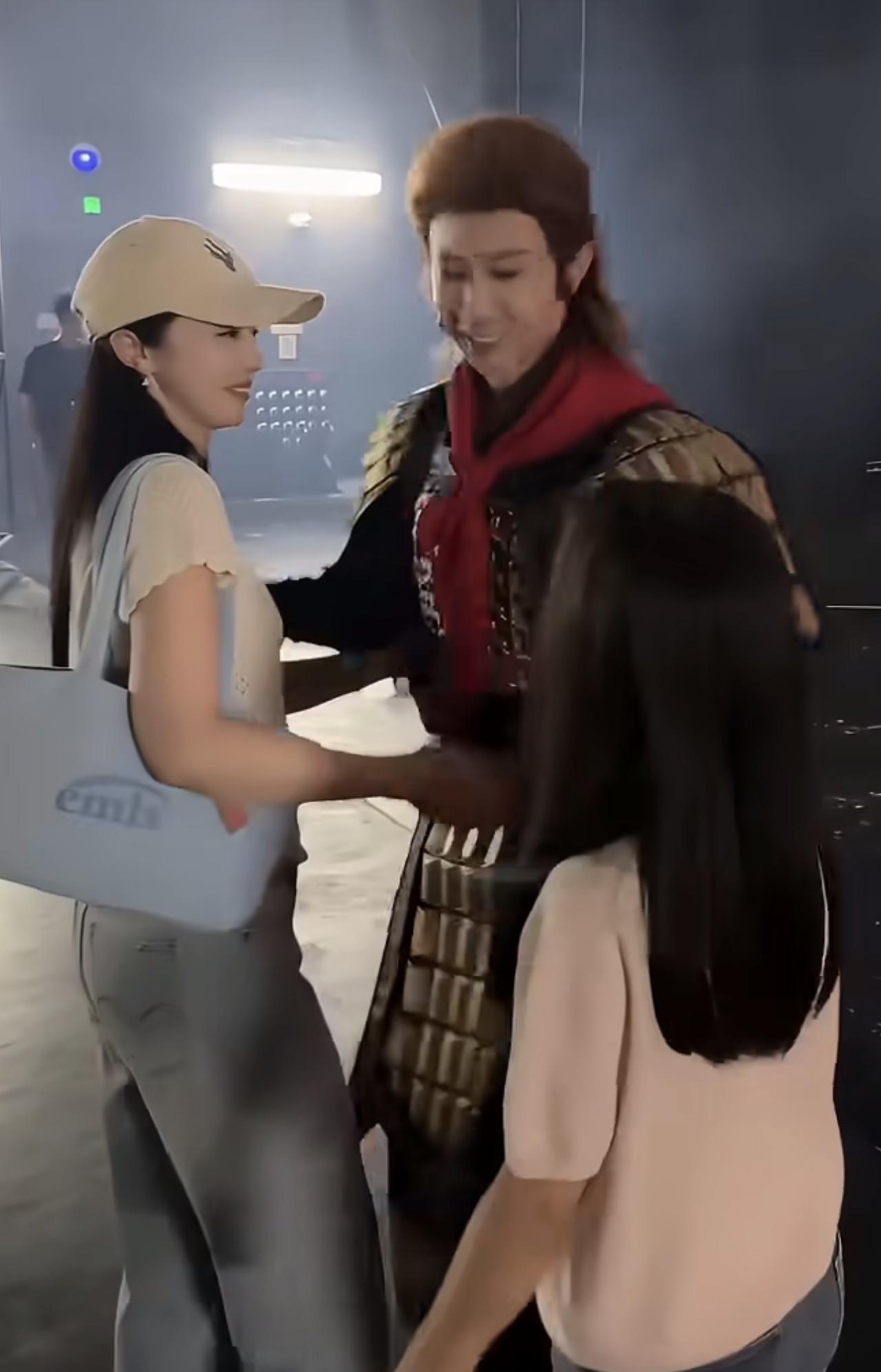 场景：舞台剧后台门口，张维伊刚谢完幕，董璇牵着小酒窝迎上去，周围还有剧组人员在