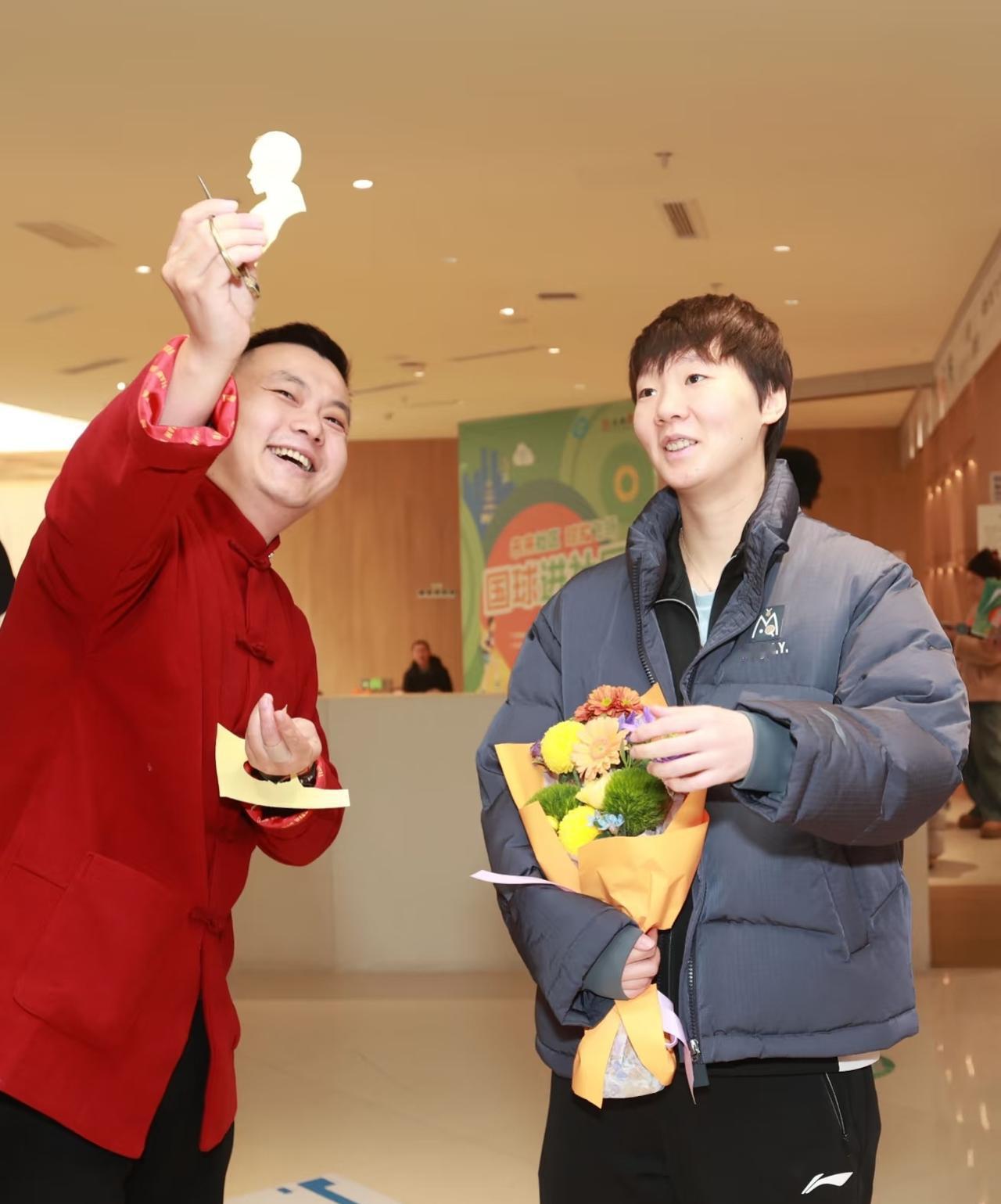 在成都武侯区一社区参加“国球进社区”活动的王曼昱，由非遗剪纸老师现场为自己速剪出