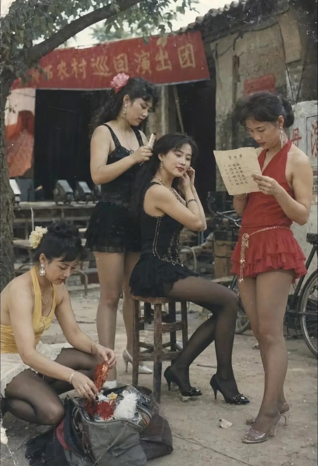 当年没有直播，听歌看戏只能等下乡歌舞团。女演员衣着时髦，在土台上卖力演出。她们四